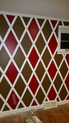 a room with red and brown squares painted on the wall, including an air conditioner