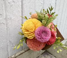 a bouquet of flowers sitting on top of a window sill in front of a white wall