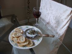 a plate with crackers on it next to a glass of wine