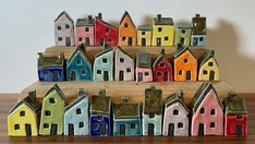 a group of small colorful houses sitting on top of a wooden table next to each other