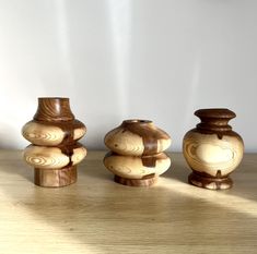 three wooden vases sitting on top of a wooden table