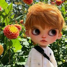 a close up of a doll near flowers