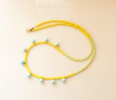 a yellow beaded necklace with blue beads