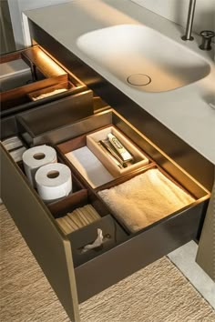 an open drawer in a bathroom with toilet paper