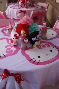 there are hello kitty decorations on the table at this birthday party, and it's so cute