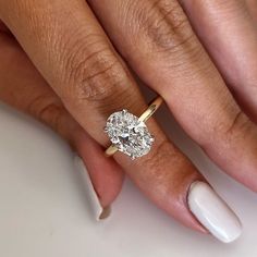 a woman's hand with a ring on her finger and a diamond in the middle