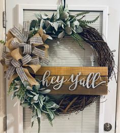 a wooden sign that says hey y'all hanging on a door with a wreath