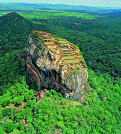 an aerial view of the rock formation in the jungle with trees and bushes surrounding it