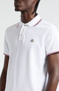 Classic tipping at the collar and cuffs enhances the sporty look of this cotton-piqué polo detailed with Moncler's signature cockerel logo at the chest. Button half-placket Rib collar Short sleeves with rib cuffs 100% cotton Dry clean or hand wash, dry flat Imported Designer Clothing Classic White Polo Shirt With Ribbed Collar, Designer White Tops With Ribbed Collar, Classic White Polo Shirt With Embroidered Logo, Classic White Polo Shirt With Contrast Collar, Classic Polo Shirt With Embroidered Logo For Work, White Sporty Polo Shirt With Contrast Collar, Classic Collared Tops With Logo Detail, Luxury White Polo Shirt With Ribbed Collar, White Polo Shirt With Contrast Trim