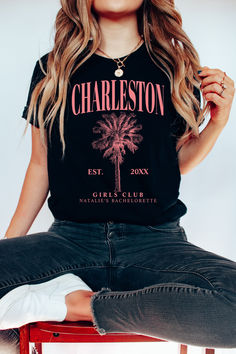 a woman sitting on top of a red chair wearing a black shirt with a palm tree