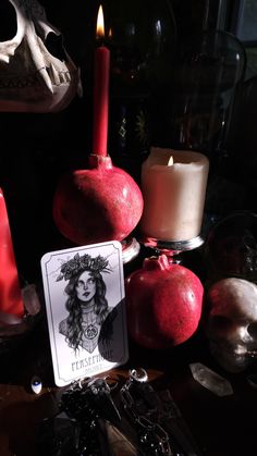 a tarot card sitting on top of a table next to some candles and skulls