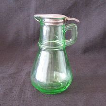 a green glass pitcher sitting on top of a table