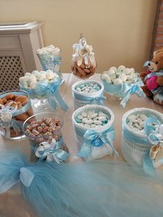 a table topped with blue and white desserts next to a framed picture on the wall