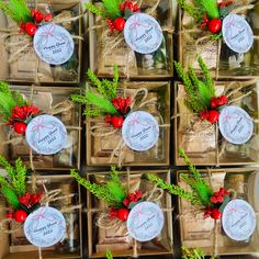 many small boxes with tags tied together and decorated with pine cones, berries and evergreen leaves