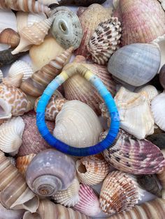 a blue bracelet sitting on top of sea shells