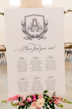 a table plan with flowers and greenery is displayed in front of a white sign