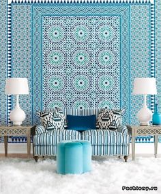 a blue and white couch sitting in front of a wall with a pattern on it