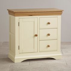 a white cabinet with three drawers and a wooden top