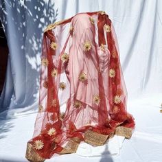 Soft elegant net dupatta with gold shimmer floral work, along with heavy border which has beads all around it. It's ideal for bridal veil, mendi, eid or parties. Measurements; length 214cm, width 110 Colour may vary due to lighting Please be sure before you order as we do not accept return, exchange or cancellations. Red Embroidered Fabric With Sheer Dupatta For Eid, Red Embroidered Sheer Dupatta Fabric For Eid, Red Sheer Dupatta Embroidered Fabric For Eid, Gold Shawl Dupatta For Wedding, Eid Shawl With Dori Work In Traditional Drape, Red Sheer Dupatta Shawl For Eid, Sheer Dupatta Shawl For Diwali, Sheer Dupatta Net Saree For Eid, Gold Organza Churidar With Dupatta