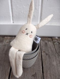 a white stuffed animal sitting in a bucket