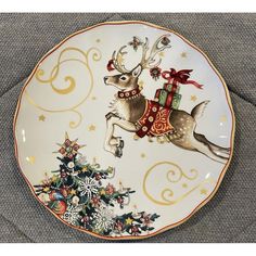 a christmas plate with a reindeer holding a present on it's back and flying through the air