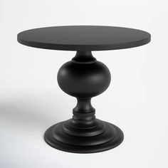 a black round table sitting on top of a white floor