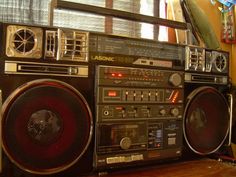 an old fashioned boombox sitting on top of a wooden floor next to a window