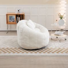 a white chair sitting on top of a rug in a living room next to a table