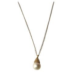 A very beautiful white cultured pearl on a 14-karat yellow gold necklace, circa mid-20th century. Pearl is very beautiful with a high luster. Pearl has a 14-karat yellow gold crown-like design at top attached to 14-karat yellow gold necklace. A beautiful piece to wear alone or stack with other necklaces (as demonstrated.) Very good condition as shown in images. No issues. Dimensions: pearl pendant is .50" long x .25" width. Necklace, from end to end, measures 19.25" long. For gold choker necklace shown, search 1stDibs ref. #: LU4068223052022 For Italian heart necklace search ref. #: LU4068222740332 Figaro Necklace, Vintage Pendant Necklace, Pearl Necklace Vintage, Turquoise Pendant Necklace, Solitaire Pendant Necklace, Yellow Gold Necklace, Cultured Pearl Necklace, Coral And Gold, Gold Choker Necklace