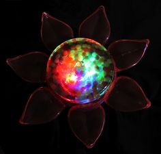 a colorful light up object sitting on top of a black surface with lots of lights