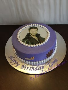 a purple and white cake with a photo on it