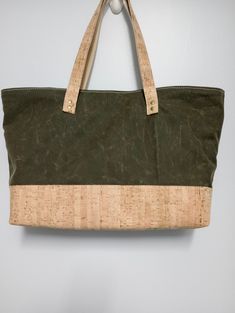 "Olive green waxed canvas tote with natural cork bottom accent and straps. Lined with waterproof canvas. Durable enough to be your everyday commuter tote. Large enough for most laptops, iPads, or other tablets.  Approximately 19\" W x 11.5\" H x 5\" D If you would like this style tote in a different color, size, or material, or to add specific pockets (such as a padded laptop pocket, water bottle holder, etc.) message me and we will collaborate to design your own tote bag." Waxed Canvas Tote Bag, Water Bottle Holder, Water Bottle Holders, Waxed Canvas, Bottle Holder, Laptop Pocket, East West, Large Tote Bag, Bottle Holders