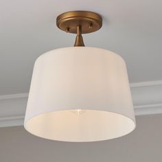 a light fixture with a white shade hanging from the ceiling