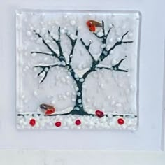 two birds sitting on the branches of a tree with snow around it and red berries in the foreground