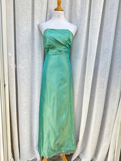 "1970's Jim Helm Occasions strapless formal dress. Made in USA. This stunning vintage dress in nice teal color features strapless style with gathered side detail. The bodice is boned for structure. Back zipper closure.  Fully lined. 100% acetate Good preowned condition. There's a small stain on the bust and few stains towards the hem (see photos ) Marked size 2. The mannequin is size 4, so I couldn't fully zip the dress. The zipper is fully functioning. Measurements (flat): Armpit to armpit: 14\" Waist: 26\" Hips: 36\" Top to hem: 51\"" Strapless Green Dress With Lined Bodice, Green Strapless Dress With Lined Bodice, Green Strapless Dress With Fitted Bodice, Green Strapless Evening Dress With Fitted Bodice, Green Strapless Dress For Prom, Green Strapless Dress With Sweetheart Neckline And Fitted Bodice, Green Strapless Dress With Fitted Bodice For Gala, Green Strapless Dress With Sweetheart Neckline For Gala, Green Strapless Dress With Sweetheart Neckline