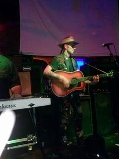 two men are playing guitars and singing on stage