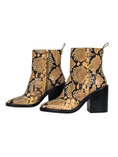 Elevate your safari chic style -- literally! You'll turn heads in these these striking boots from Tory Burch! Made with a sleek snakeskin embossed design and bold chunky heel, these bad boys are perfect for bohemian babes and party princesses alike! Pair with a maxi dress and chunky headband for a 70's-inspired look or hit the club in style with your favorite LBD and bouncy curls. No matter how you rock these beauties, you're sure to be fierce! Size 9.5 Leather upper with snakeskin embossed desi Black Snake Print Boots For Fall, Fall Snake Print High Heels, Fall Snake Print High Heel Boots, Snake Print Leather Boots With Pointed Toe, Snake Print High Heel Boots For Fall, Chic Snake Print Boots With Block Heel, High Heel Snake Print Boots For Fall, Trendy Snake Print Ankle Boots, Fall Snake Print Ankle Boots