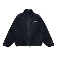 a black jacket with zippers on the front and side, featuring an embroidered logo