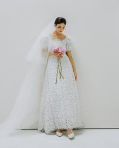 a woman in a white dress holding a bouquet of flowers