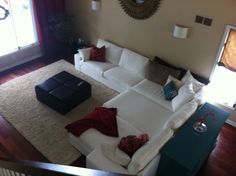 a living room filled with furniture and a large mirror on the wall above it's windows