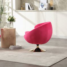 a pink chair sitting on top of a white rug next to a potted plant