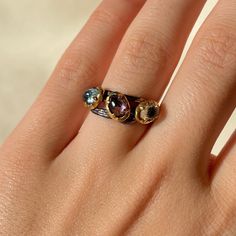 This 925 Sterling Silver adjustable band ring is purely handmade. Black Sterling Silver band part is Rhodium plated and bezels around the crystals are 18k Gold plated. Natural faceted Blue Topaz, Amethyst and Green Tourmaline crystals are used. The size of the ring can be adjusted easily by hand. Blue Topaz: * color blue carries soothing energy and brings peace * helps releasing tensions * stimulates creativity * teaches self-love and self-realization * deflects negative energy * provides emotio Gold Twig Ring, Gold Twigs, Green Tourmaline Crystal, Valentines Gift For Her, Ring Three Stone, Twig Ring, Topaz Color, Minimalist Ring, Tourmaline Ring