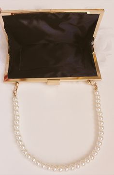 Keep your ensemble looking gorgeous and chic with the Quinn Purse. With a glossy white pearl bead strap and feather body, The Quinn Purse is perfect for any bridal occasion. Open the rectangular top clasp to reveal a roomy, fabric-lined interior with an attached gold chain strap. Details: Removable gold chain: 46 inches Width: 8 inches Length: 6 inches This purse is large enough to hold your cell phone plus a few small item. Lining: black Final Sale Glossy White, White Pearl, Pearl Beads, Chain Strap, Pearl White, Gold Chain, Gold Chains, 6 Inches, Final Sale