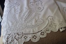 an embroidered tablecloth with white flowers on it