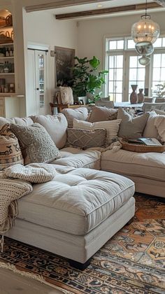 a living room filled with lots of furniture and pillows on top of a large rug