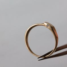 As a unique midi ring, or worn as a slender ring to add to your stack, the slender Ouroboros snake hugs your finger with the glint of two black diamonds as a minimalist symbol of rebirth. Wear with love. details ⬦ 3mm tall ouroboros band depicting a tiny serpent eating it's tail ⬦ Band width 1.75mm around the back, ring face is just over 3mm wide (shown worn with a .8mm gold band for scale) ⬦ Unisex band to wear on it's own or pair it with a partner ⬦ Pictured here cast in 14k yellow gold, set w Minimalist Jewelry With Bezel Setting For Promise, Minimalist Promise Jewelry With Bezel Setting, Symbolic Hand Forged Ring Jewelry, Unique 14k Gold Jewelry With Ring Detail, Hand Forged Yellow Gold Jewelry For Promise, Hand Forged Yellow Gold Promise Jewelry, Symbolic Open Ring Jewelry With Ring Detail, Minimalist Hand Forged Open Ring Jewelry, Minimalist Engraved Brass Rings