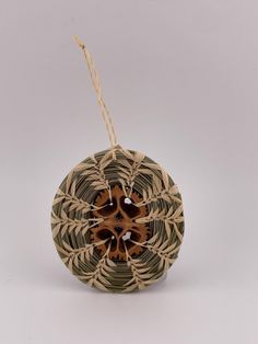 an ornament made out of woven material with brown and black designs on it