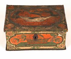 an old wooden box with painted designs on it's sides and a lock at the top