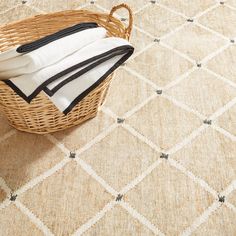 a basket filled with towels sitting on top of a floor next to a white rug