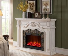 a white fireplace with an electric fire in the center and two framed pictures above it